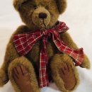 Collectible medium brown Boyd’s furry bear with jointed legs, swivel head, and red plaid neck ribbon, 11.5″